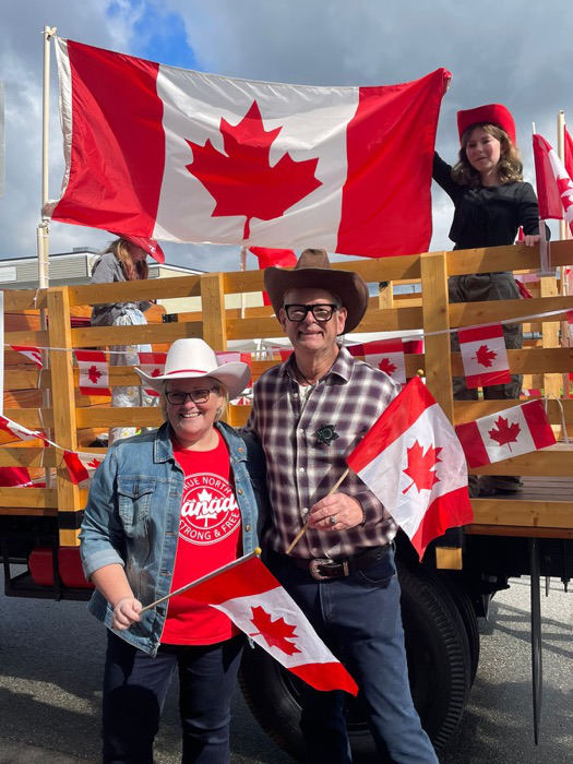 Ernie with residents waving Canadian flags